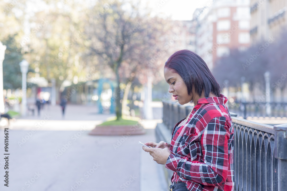 Smiling young woman with smart phone in the street. Smiling young woman with smart phone in the street.