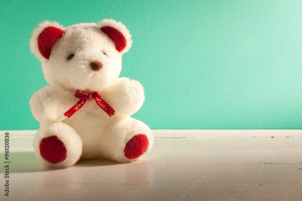 Fototapeta premium beautiful white teddy bear on white,green wood background.