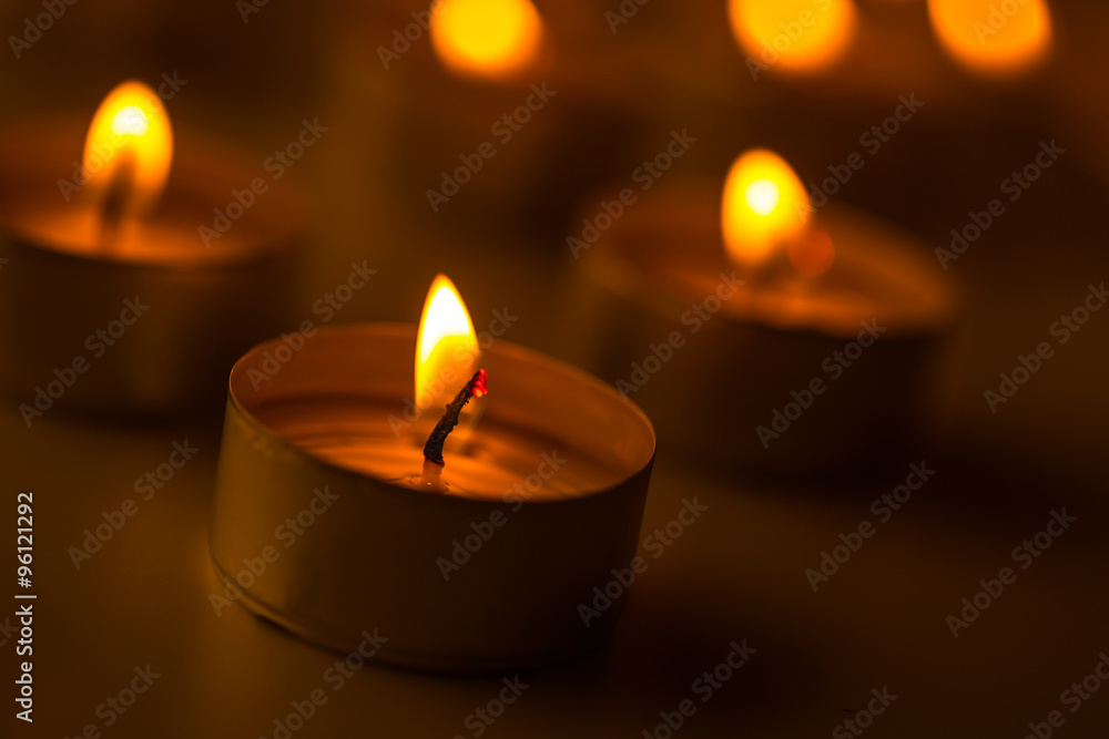 Candles light. Christmas candles burning at night. Abstract candles background. Golden light of candle flame.