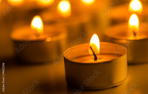 Candles light. Christmas candles burning at night. Abstract candles background. Golden light of candle flame.
