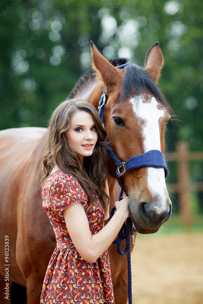 Obraz premium Beautiful young woman with a horse outdoor