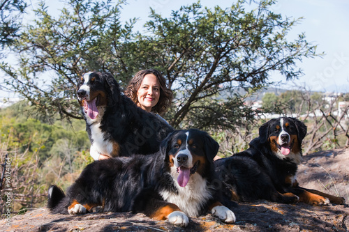 Frau sitzt mit ihren Hunden auf Stein