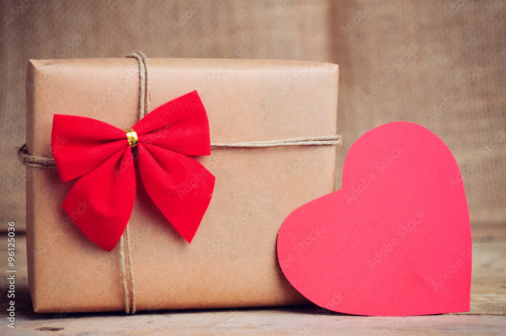 Christmas paper box with heart decoration on wooden surface Christmas paper box with heart decoration on wooden surface