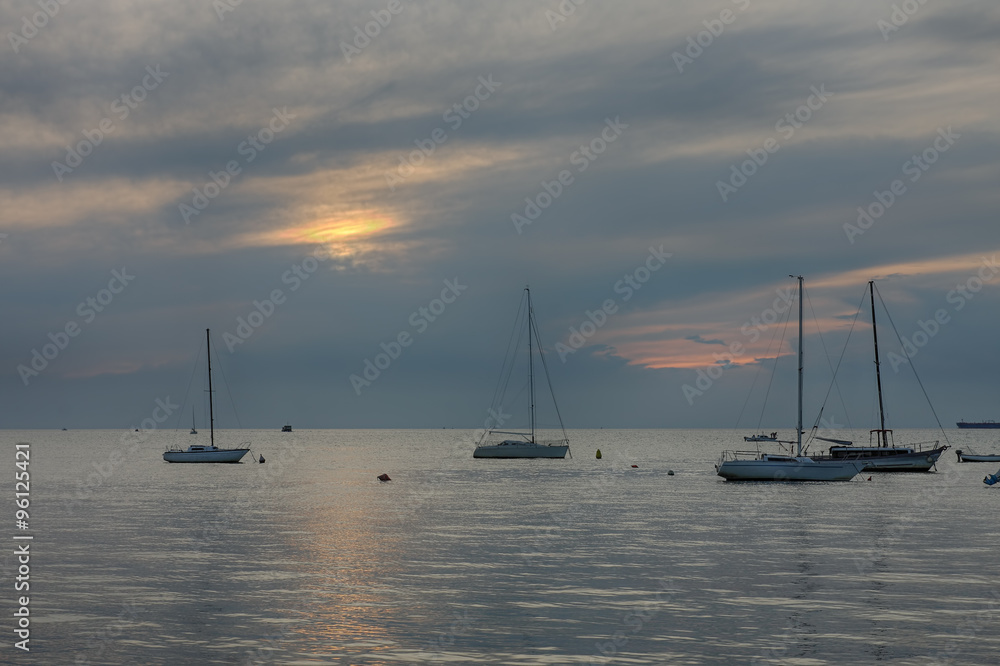 Sailboats on open sea in a summer at sunset time
