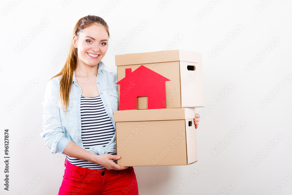 Woman moving into home with boxes and paper house. Woman moving into home with boxes and paper house.