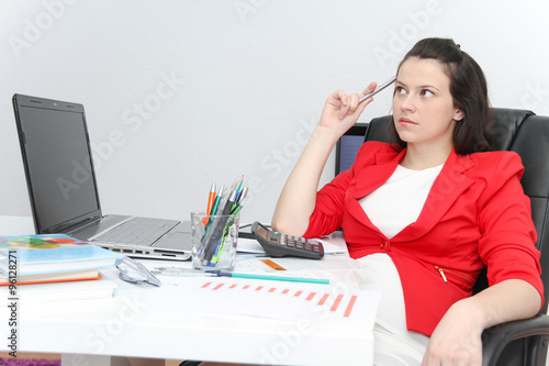 Pretty Business woman analyzing investment charts with calculato photo