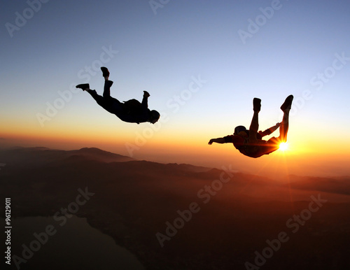Obraz na plátně Skydivers at the sunset