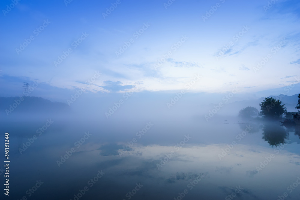 lake in fog in blue sky