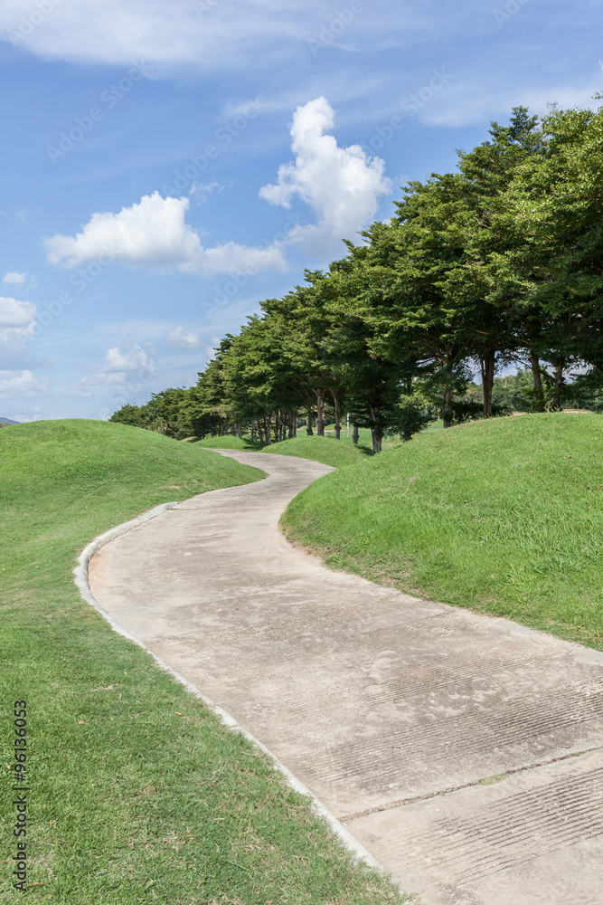 The curved pathway green golf course and beautiful nature scene.