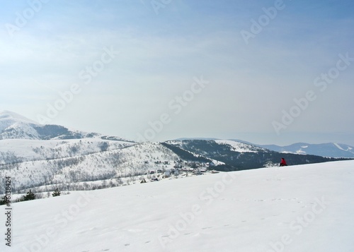 Beautiful, idyllic snowy winter landscape in the mountains, on a crisp sunny morning; hills and slopes; nature.