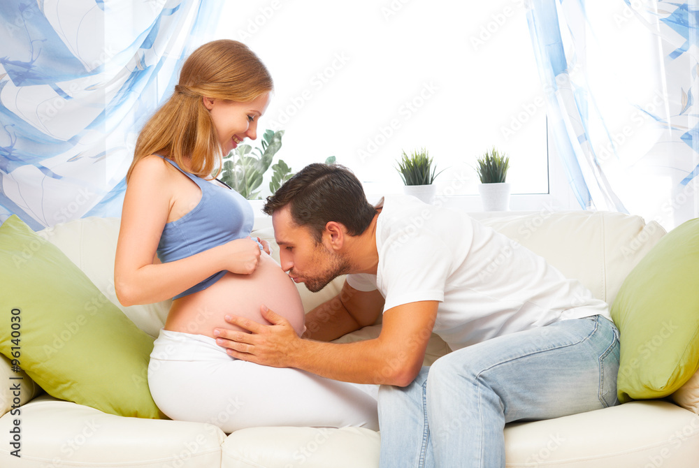 happy family in anticipation of birth of baby. man kissing belly happy family in anticipation of birth of baby. man kissing belly