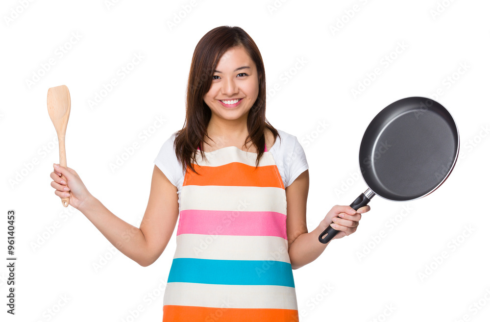 Asian Housewife holding up with wooden ladle and frying pan Asian Housewife holding up with wooden ladle and frying pan
