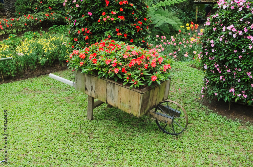 Idyllic flower garden with old wooden cart. flower cart.