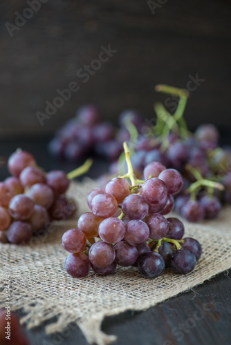 Wallpaper Mural Bunch of grapes in the basket on wooden table Torontodigital.ca