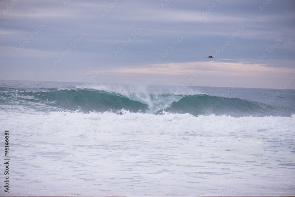 Fototapeta premium Wave crashing on a coast in Nazare, Portugal.