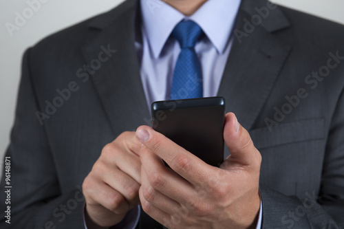 Close up of business man hands holding mobile phone