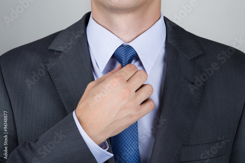 Business man adjusting his neck tie