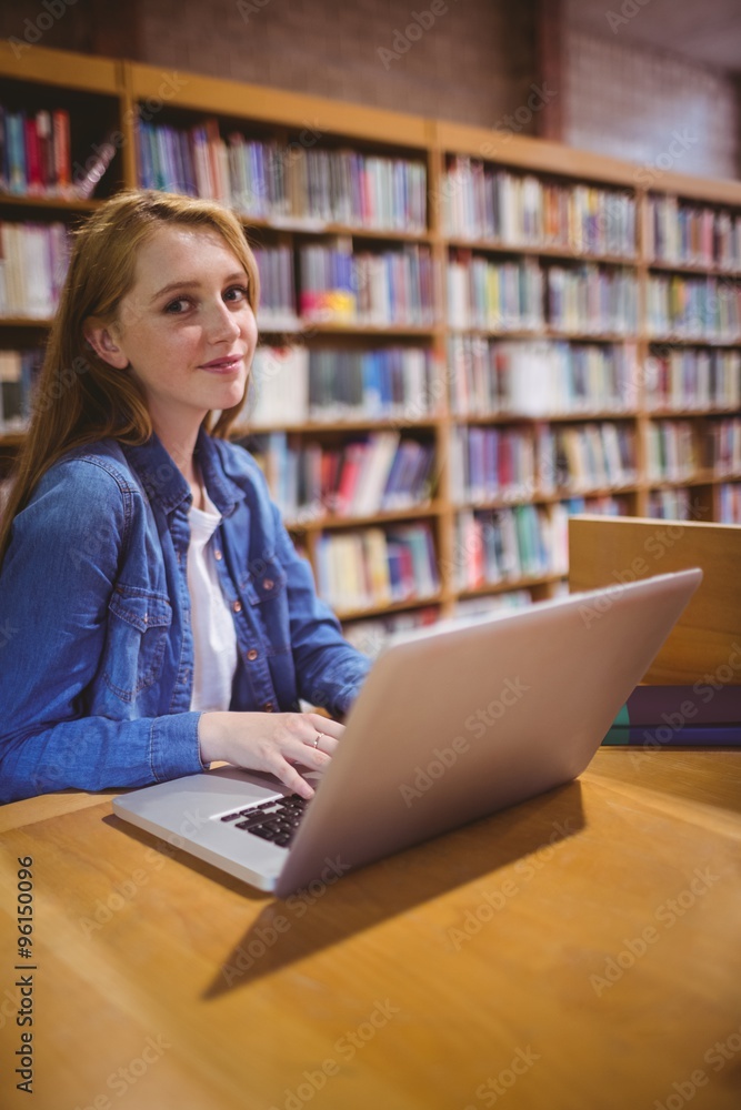 Blond student using laptop in library Blond student using laptop in library
