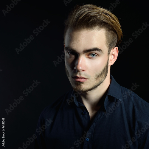 Portrait of beautiful charming young man with blue eyes and fair