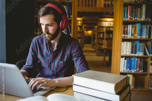 Hipster student studying in library photo