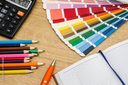 Blank paper and colorful pencils on the wooden table