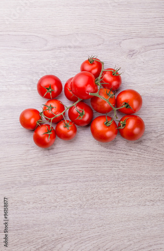 Fresh cherry tomatoes on rustic wooden background