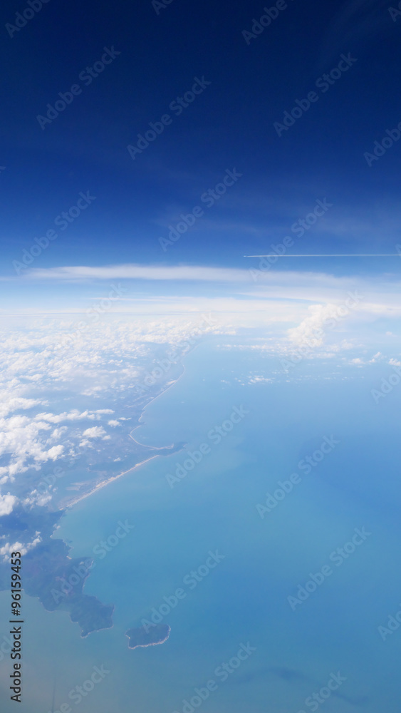 Land and sea under blue sky, view from the airplane. (1)