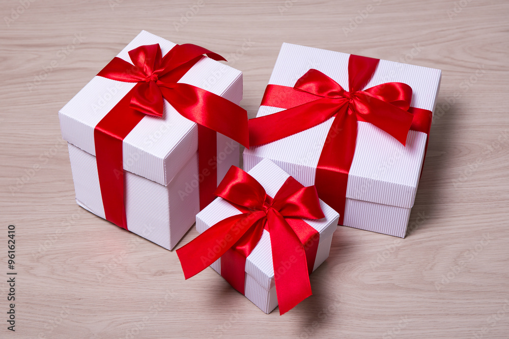 Fototapeta premium gift boxes with red ribbon on wooden background