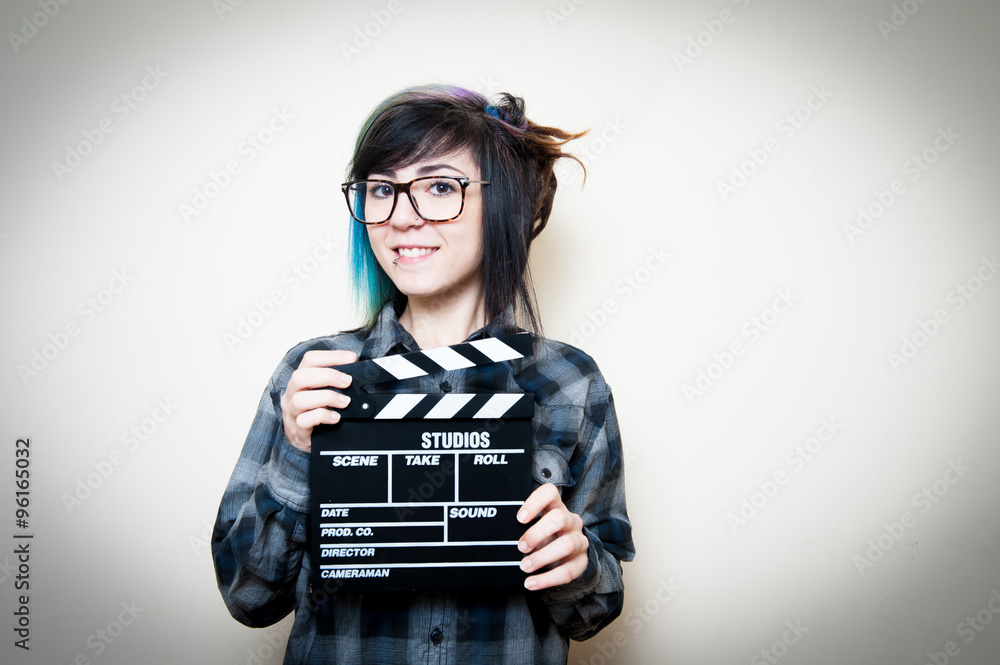 Smiling teen woman with clapper board