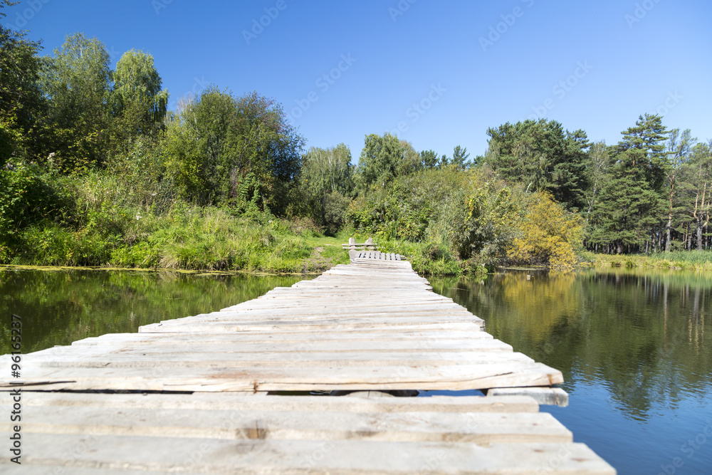 The old makeshift bridge connecting the two banks of a small lake The old makeshift bridge connecting the two banks of a small lake