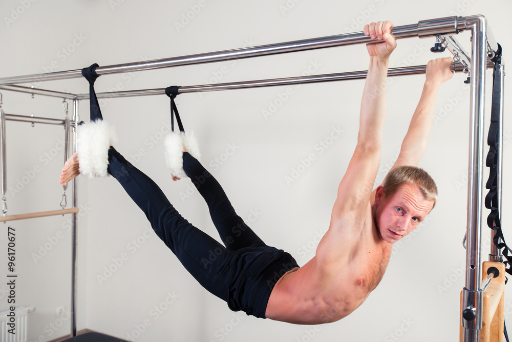 Pilates aerobic instructor man in cadillac fitness exercise