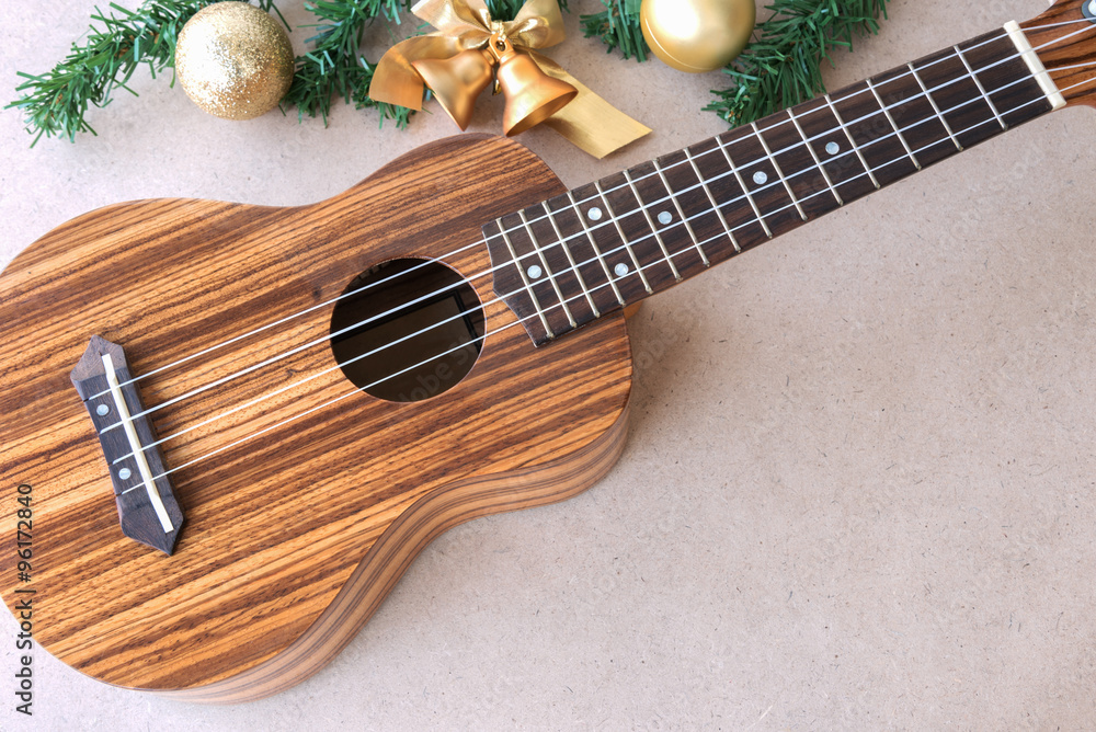 Fototapeta premium The ukulele on the wooden table with christmas decoration