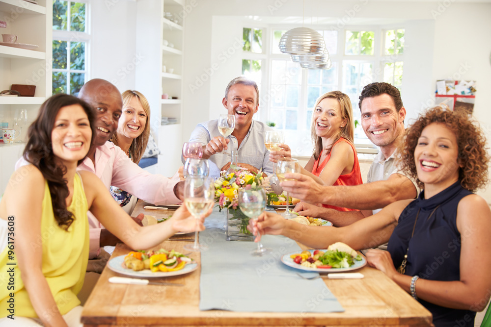 Portrait Of Mature Friends Around Table At Dinner Party