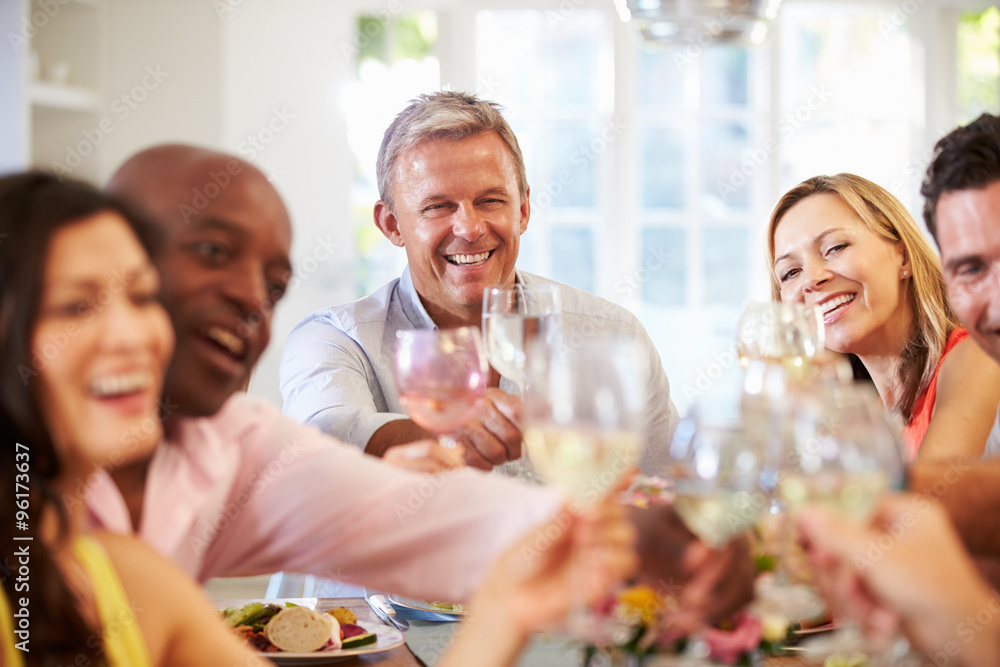 Mature Friends Sitting Around Table At Dinner Party Mature Friends Sitting Around Table At Dinner Party