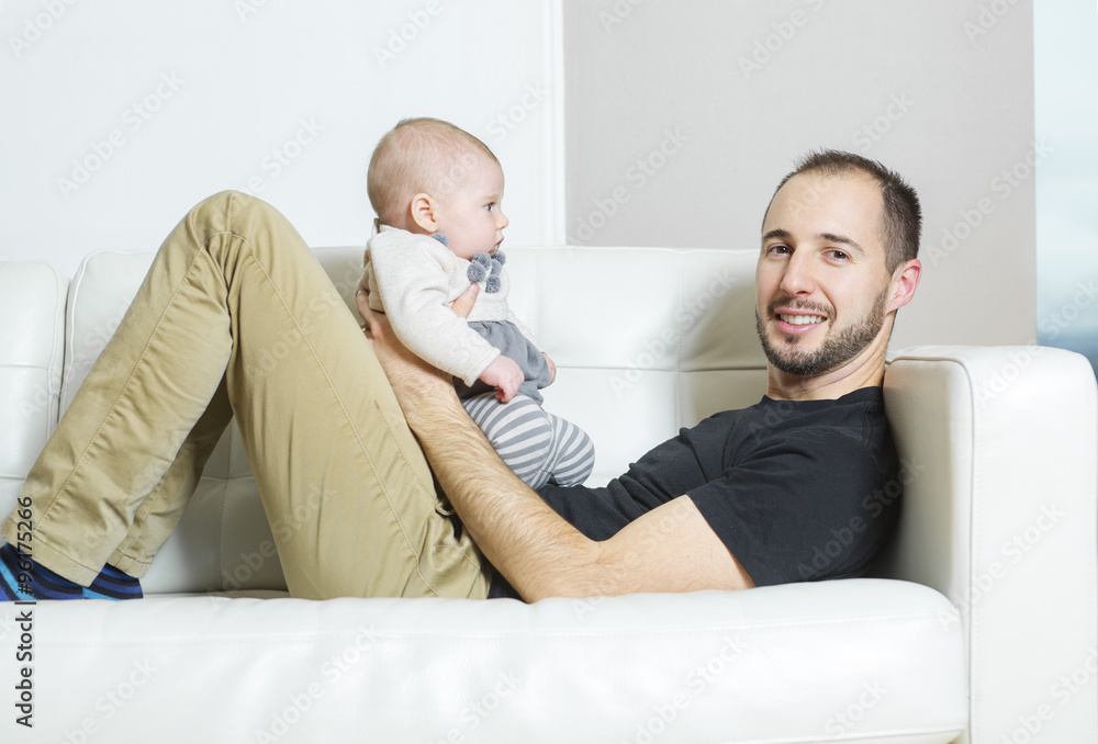 Father with baby on the sofa taking good time Father with baby on the sofa taking good time
