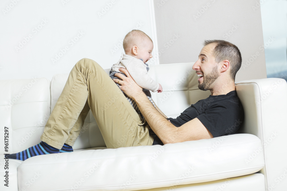 Father with baby on the sofa taking good time Father with baby on the sofa taking good time
