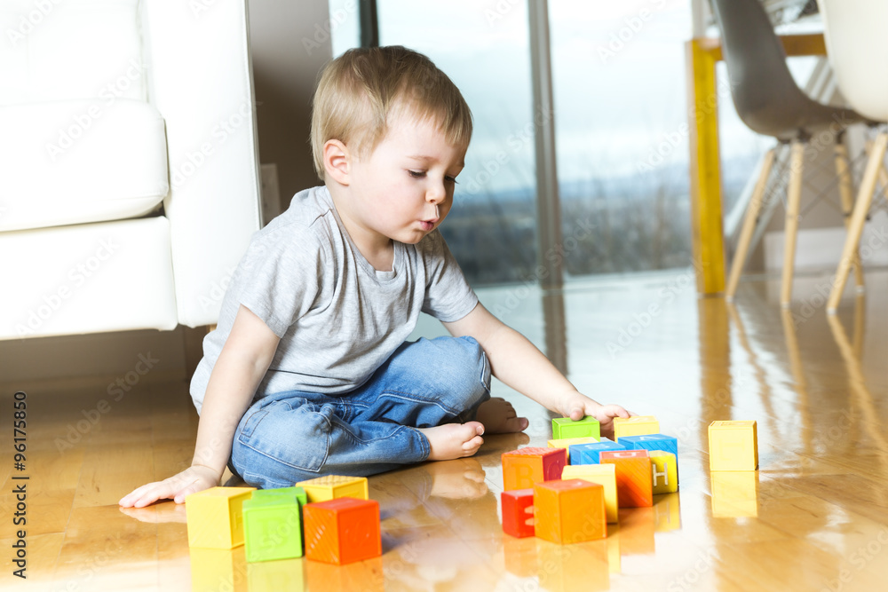 kid playing toy blocks inside his house kid playing toy blocks inside his house