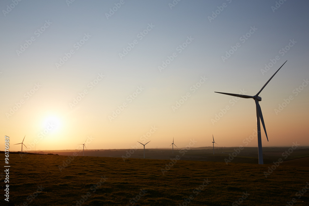 Group Of Wind Turbines In Field At Dusk