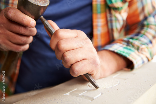 Close Up Of Stone Mason At Work On Carving In Studio