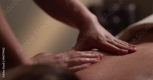 Back Massage Low Angle. camera moves right on a low angle shot of a spa employee giving a back massage to a client.
