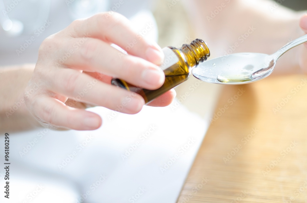 Obraz premium Tropfen werden auf einen Löffel gegeben