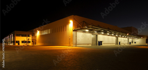 External wide angle view of modern warehouse at night