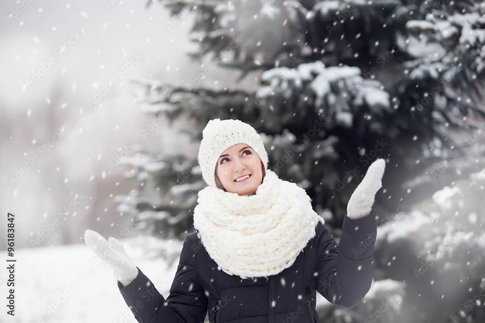  Portrait of a young pretty woman outdoors under snovfall.