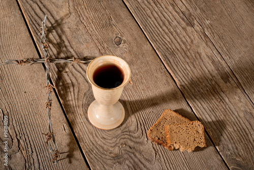 Chalice and bread on the wooden table