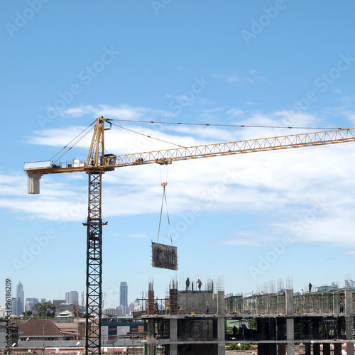 Industrial landscape with cranes on the blue sky