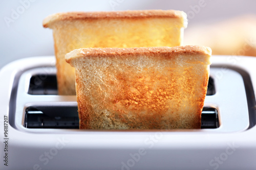 Slika na platnu A couple of crusty toast in the toaster, close-up