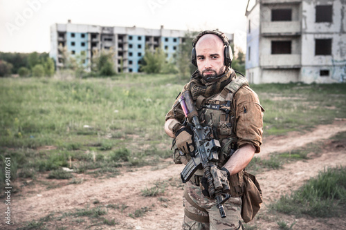 Soldier with the rifle on the ruined city background.