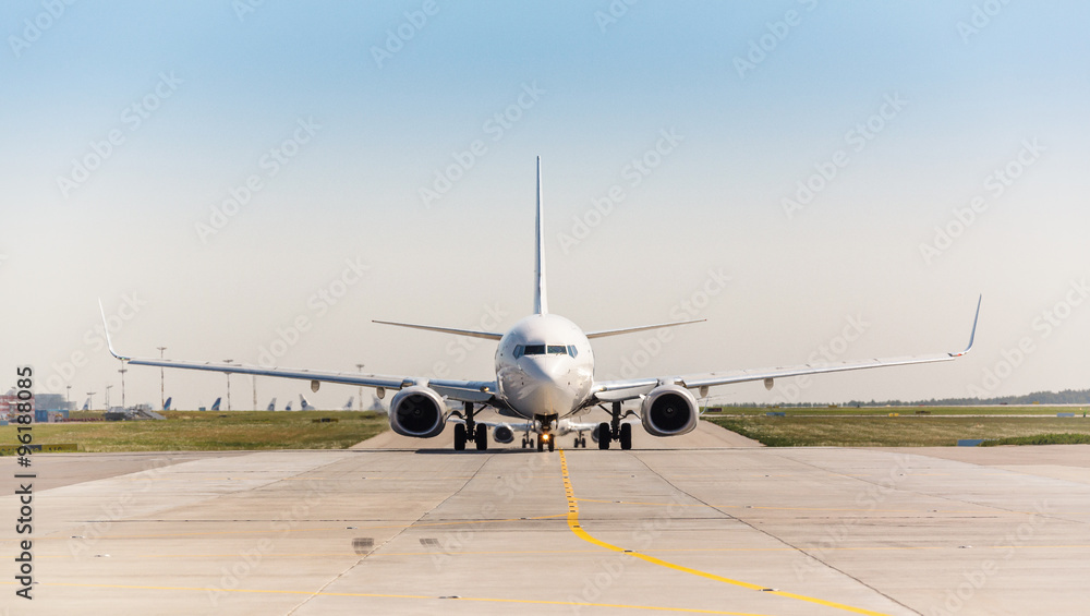 Obraz premium Biały samolot odrzutowy na pasie startowym