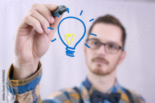 Man having an idea, drawing a light bulb 