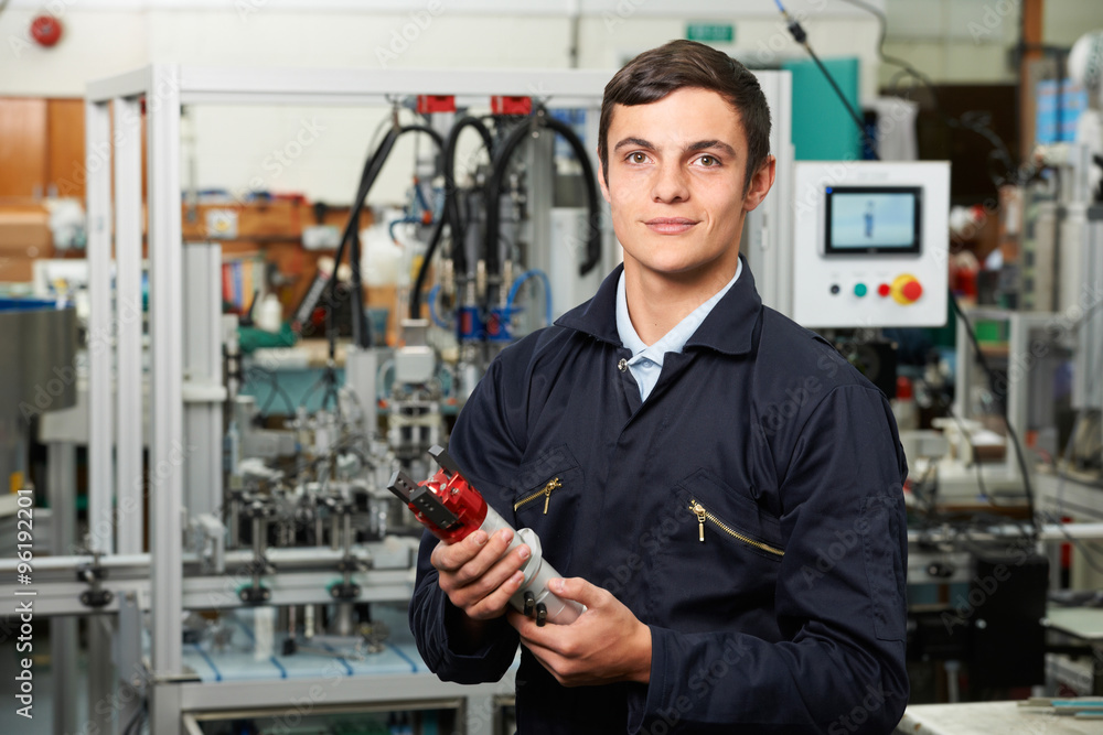 Apprentice Engineer Checking Component In Factory Apprentice Engineer Checking Component In Factory